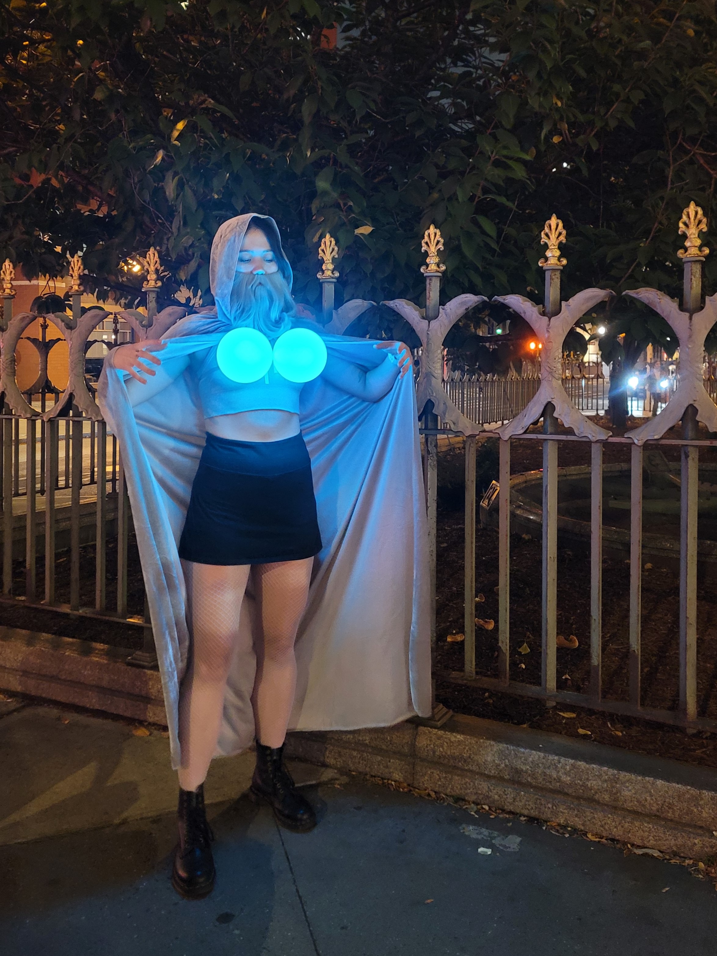 Heidi Erwin in a wizard costume with a grey beard, grey cloak, blue fishnet tights, and two glowing blue orbs where someone's boobs would be.